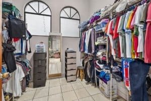 Organized walk-in closet with clothes, shoes, and storage solutions in a home.