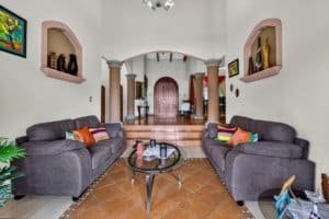 Interior of a spacious living room with two sofas, colorful pillows, and mountain view.