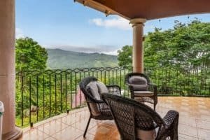 Balcony with chairs overlooking lush green mountains in Dominical, Costa Rica.