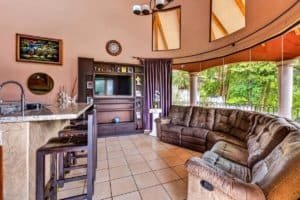 Comfortable sectional sofa and entertainment center in a bright living room with balcony views.