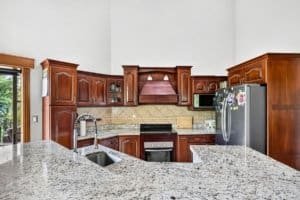 Large kitchen with wooden cabinets, granite countertops, and mountain views.