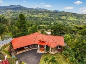 Large home with red roof in lush green landscape near Dominical, Costa Rica.