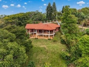 Large house with panoramic mountain views surrounded by lush greenery in Dominical.