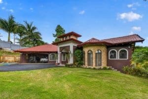 Beautiful Costa Rican home with lush garden and mountain backdrop.